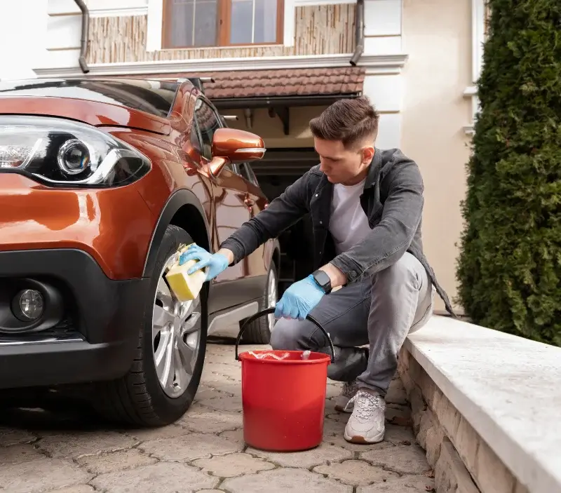 Lavage auto à domicile Enveitg : professionnel intervenant sur un véhicule